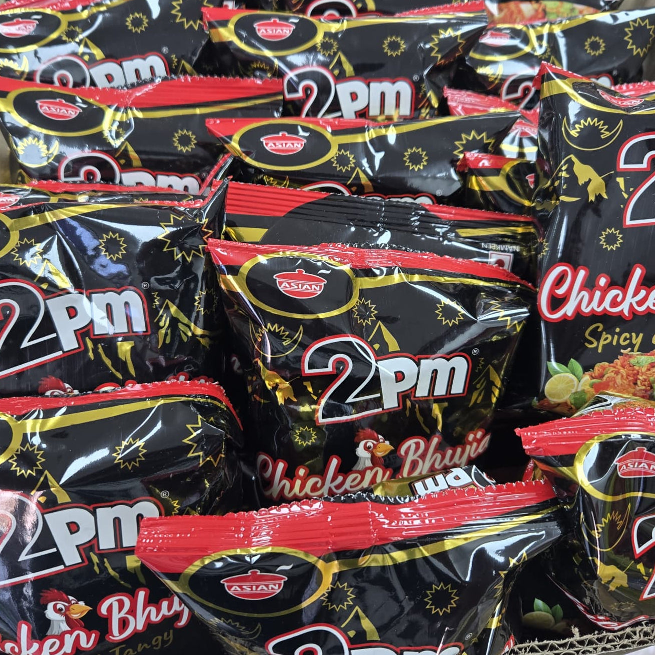 Assorted 2pm snack packages including Chicken Bhaji and Spicy & Tangy flavors.