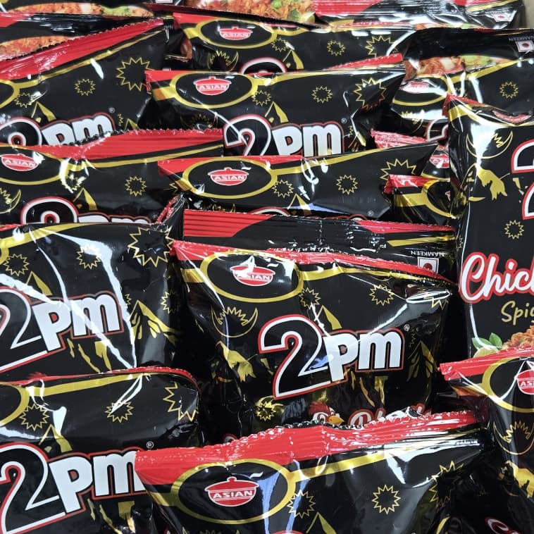 Box of 2pm Chicken Bhujia snack packets on a table with other products.
