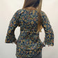 Back view of a blue floral kalamkari print short tunic kurti with 3/4 sleeves and white fringe lace border