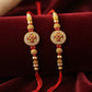 Set of two gold Swastik rakhis with red thread and beads