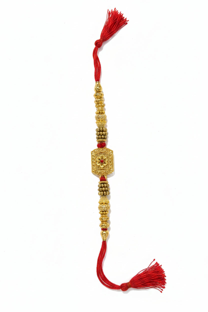 Gold square designer rakhi with red thread and intricate detailing