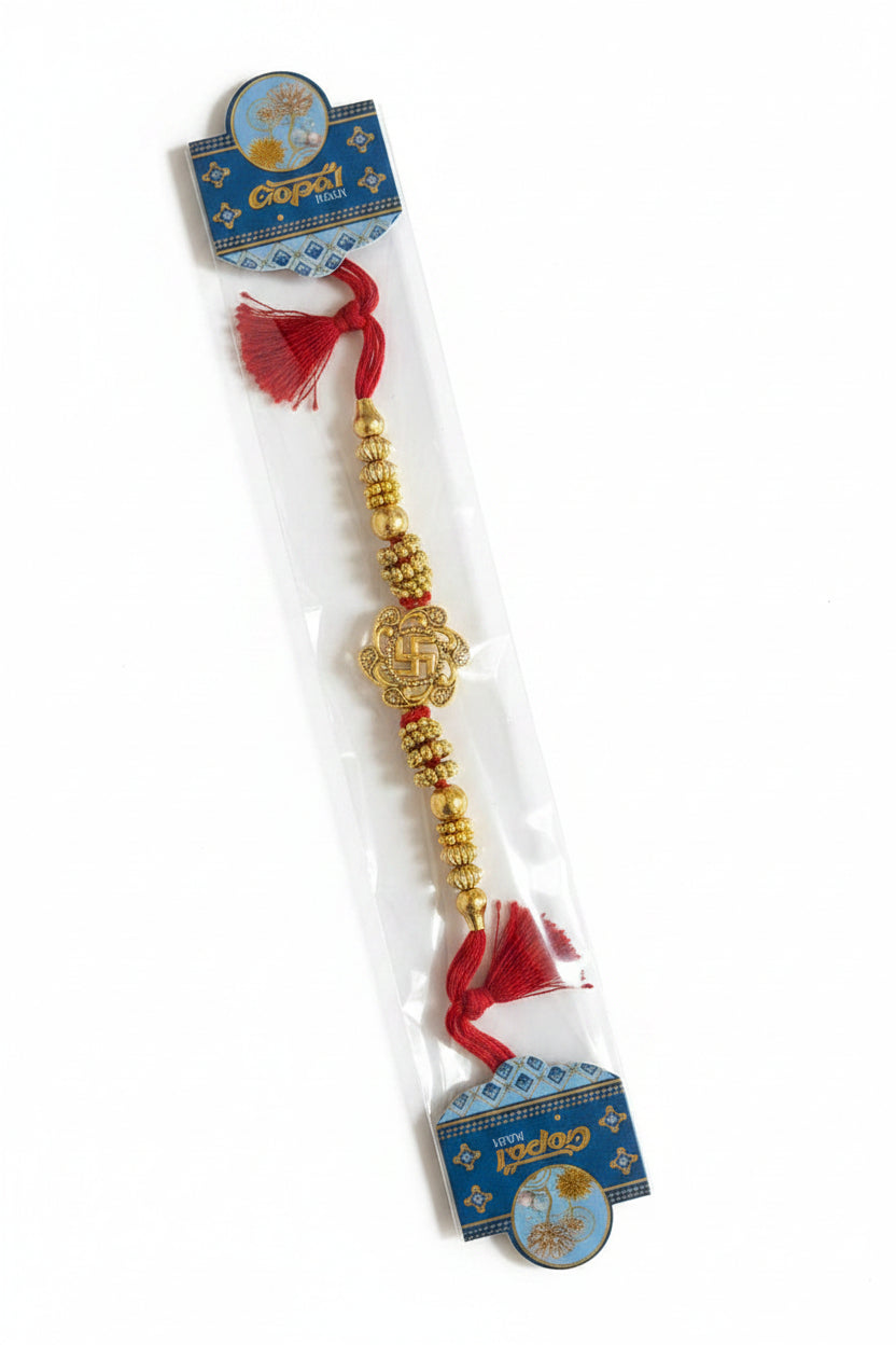 Gold Swastik rakhi with red thread and traditional bead detailing