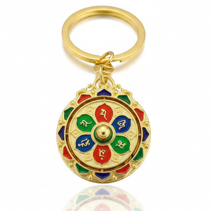 Gold Tibetan prayer wheel keychain with red blue and green symbolic accents