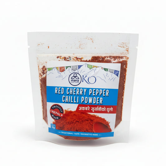 Front packaging of Mana KO Red Cherry Pepper Chilli Powder 50g showing a vibrant pile of ground red chilies and Himalayan prayer flags.