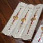 Red and gold designer rakhi set with beads and decorative centerpiece