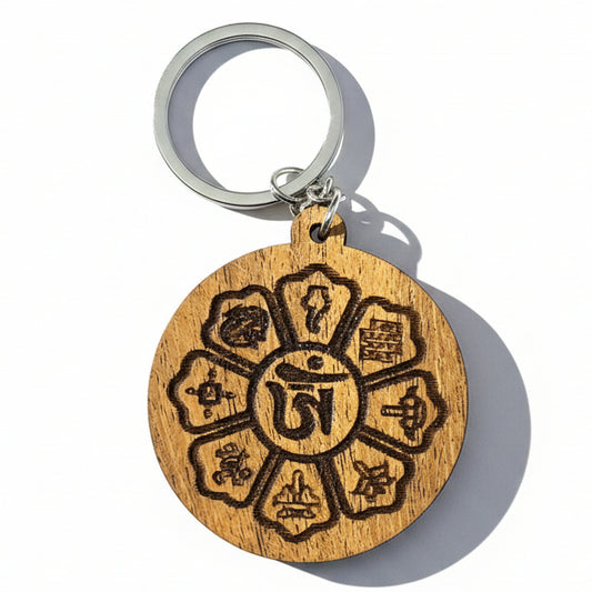 Round wooden Tibetan-inspired keychain with central Om symbol and engraved symbolic designs