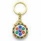 Silver Tibetan prayer wheel keychain with red blue and green symbolic accents