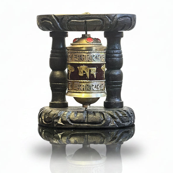 Tibetan Buddhist prayer wheel with Om Mani Padme Hum mantra and carved dark wooden display stand