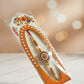 Traditional floral beaded rakhi with pearl and gold accents