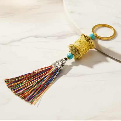 Gold Tibetan prayer wheel keychain with multicolor tassel